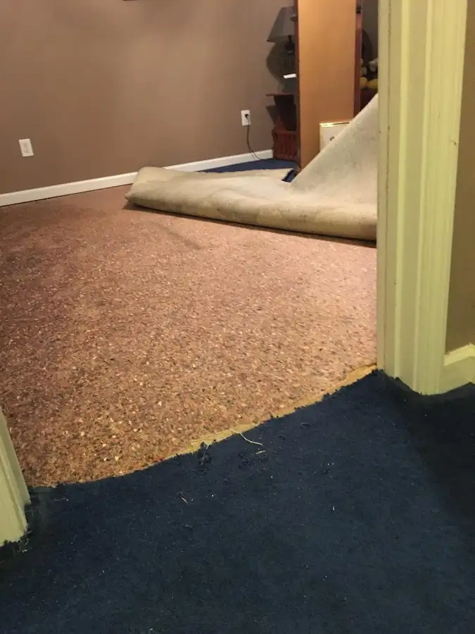 Carpet pad removal revealing water damage during Water Mitigation Services in Lewisboro